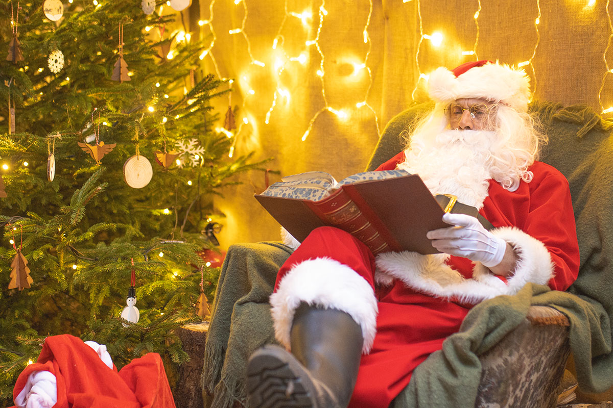Santa Claus sat in a chair reading a book