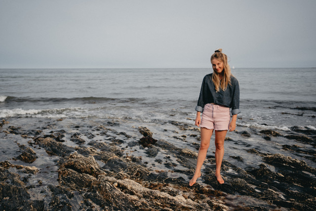 Wellness coach Emily Wheeler stood on the coastline with sea behind