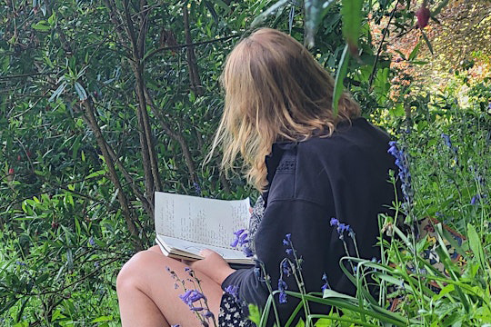 lady writing among bluebells