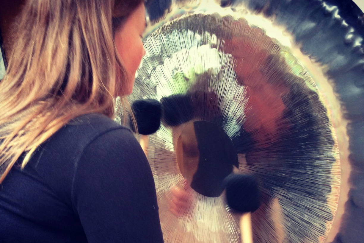 A woman hitting a large gong